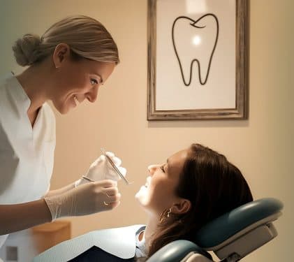 A dentist cleaning a smiling patient's teeth.